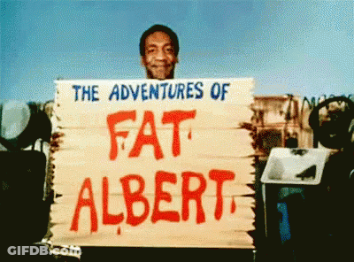 A Man Is Holding A Sign That Says " The Adventures Of Fat Albert " GIF