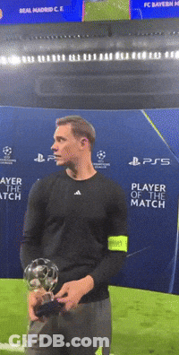 A Man Is Holding A Soccer Ball In Front Of A Sign That Says Player Of The Match GIF