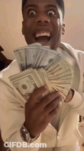 A Man Is Holding A Stack Of 100 Dollar Bills In His Hands GIF