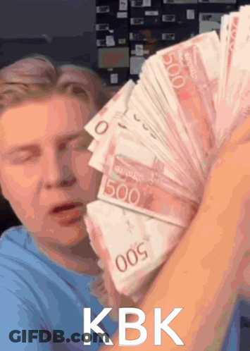 A Man Is Holding A Stack Of 500 Bills In His Hand GIF