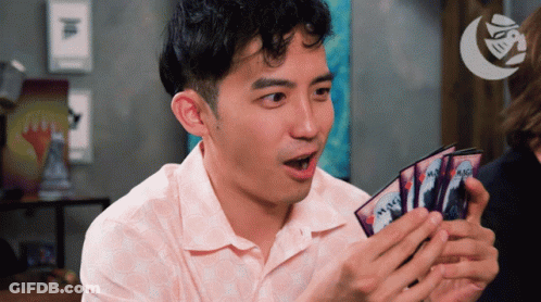 A Man Is Holding A Stack Of Magic Cards In His Hands GIF