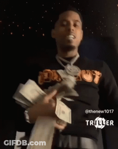 A Man Is Holding A Stack Of Money In His Hands . GIF