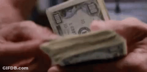 A Man Is Holding A Stack Of Money In His Hands . GIF