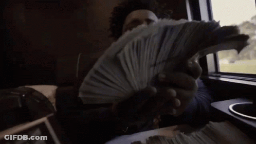 A Man Is Holding A Stack Of Money In His Hands While Sitting In A Car . GIF