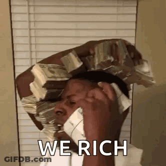 A Man Is Holding A Stack Of Money On His Head And Talking On A Cell Phone . GIF