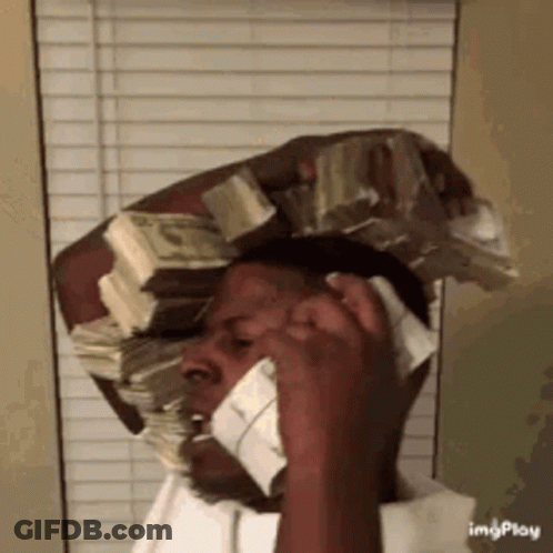 A Man Is Holding A Stack Of Money On His Head While Talking On A Cell Phone . GIF