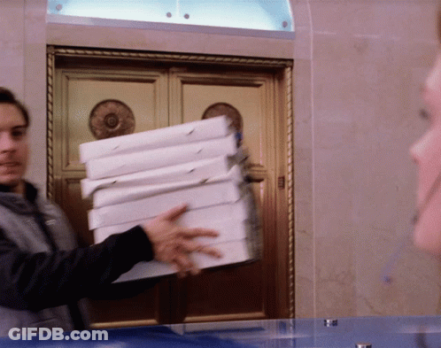A Man Is Holding A Stack Of Pizza Boxes GIF