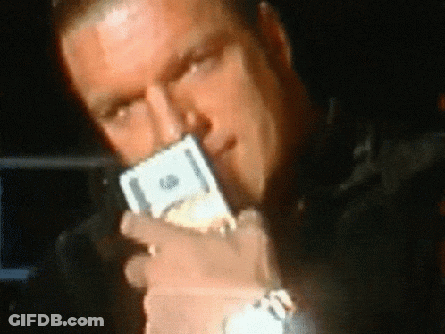 A Man Is Holding A Stack Of Twenty Dollar Bills In His Mouth GIF