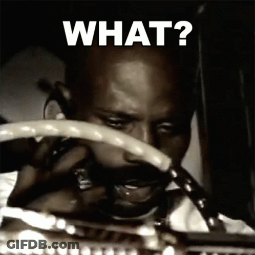 A Man Is Holding A Steering Wheel With The Words What Written On It GIF