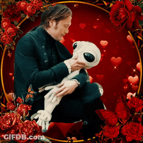 A Man Is Holding A Stuffed Animal Surrounded By Roses And Hearts GIF