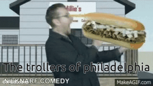 A Man Is Holding A Sub Sandwich In Front Of A Millie 'S Restaurant GIF