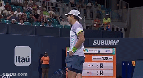 A Man Is Holding A Tennis Racquet In Front Of A Scoreboard With Subway Written On It GIF