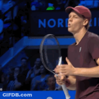 A Man Is Holding A Tennis Racquet In Front Of A Sign That Says Nor GIF