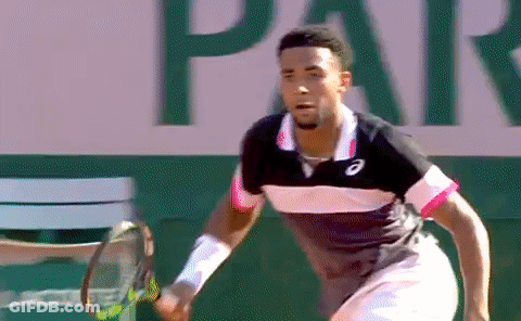 A Man Is Holding A Tennis Racquet In Front Of A Sign That Says Par . GIF