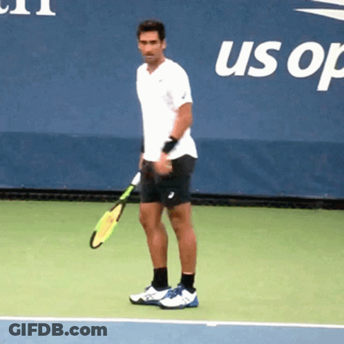 A Man Is Holding A Tennis Racquet On A Tennis Court In Front Of A Banner That Says Us Open GIF