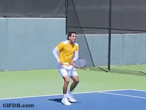 A Man Is Holding A Tennis Racquet On A Tennis Court GIF