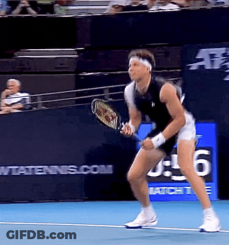 A Man Is Holding A Tennis Racquet On A Tennis Court With A Sign That Says Wtatennis.com In The Background GIF
