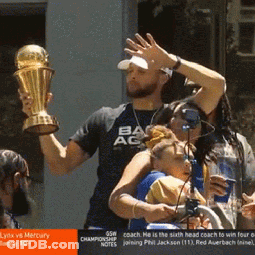 A Man Is Holding A Trophy And Wearing A Shirt That Says Ac GIF
