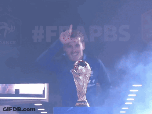 A Man Is Holding A Trophy In Front Of A Sign That Says #Frappbs GIF