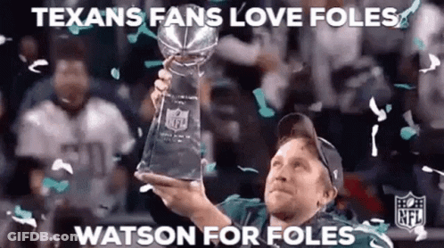 A Man Is Holding A Trophy In His Hand While Confetti Falls Around Him . GIF