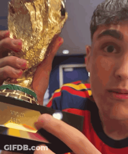 A Man Is Holding A Trophy That Says ' Fifa ' On It GIF
