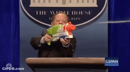 A Man Is Holding A Water Gun In Front Of A White House Logo GIF