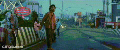 A Man Is Holding A Woman 'S Hand While Standing On The Side Of A Street . GIF