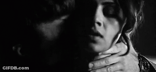 A Man Is Holding A Woman 'S Neck And Kissing Her In A Black And White Photo . GIF