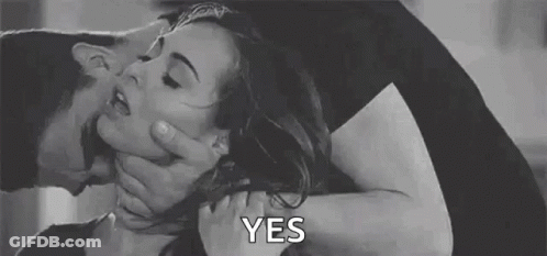 A Man Is Holding A Woman 'S Neck While Kissing Her . GIF