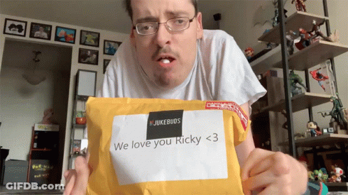 A Man Is Holding An Envelope That Says " We Love You Ricky < 3 " GIF