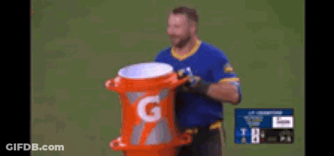 A Man Is Holding An Orange Gatorade Container GIF