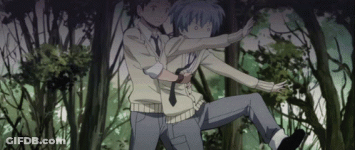 A Man Is Holding Another Man In A Forest GIF