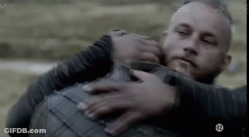 A Man Is Holding Another Man In His Arms While They Are Fighting . GIF
