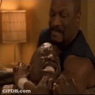 A Man Is Holding Another Man 'S Head In His Arms . GIF