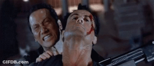 A Man Is Holding Another Man 'S Neck With His Mouth Open While Holding A Gun . GIF