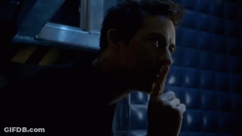 A Man Is Holding His Finger To His Mouth And Making A Silence Gesture . GIF
