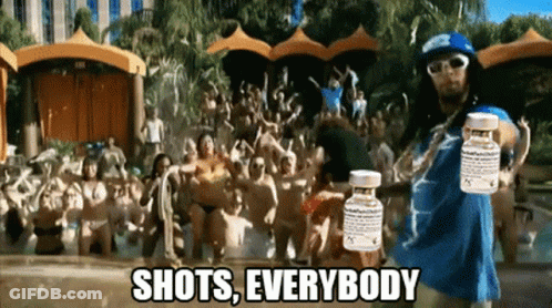 A Man Is Holding Two Bottles Of Pills In Front Of A Crowd And The Caption Shots Everybody GIF