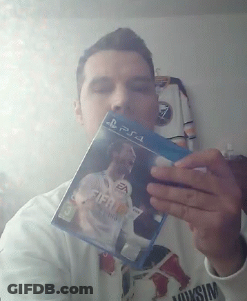A Man Is Holding Up A Fifa 18 Video Game For Ps4 GIF