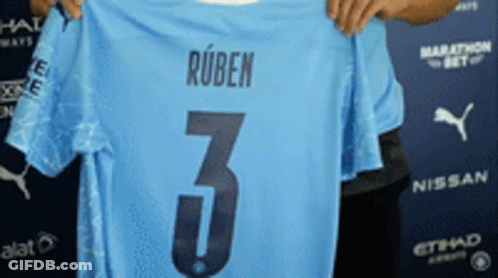 A Man Is Holding Up A Light Blue Jersey With The Number 3 On It GIF