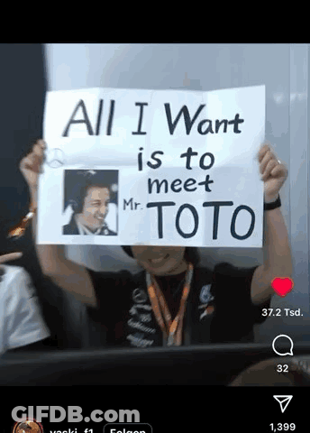 A Man Is Holding Up A Sign That Says All I Want Is To Meet Mr. Toto GIF