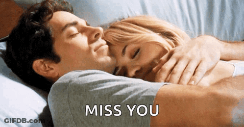 A Man Is Hugging A Woman In A Bed With The Words Miss You Written On The Bottom GIF