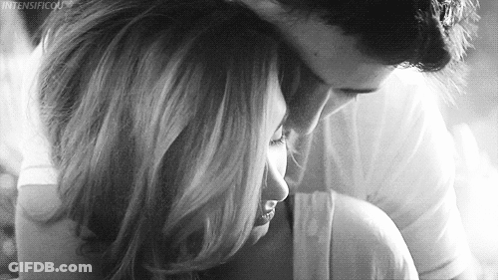 A Man Is Hugging A Woman In A Black And White Photo . GIF