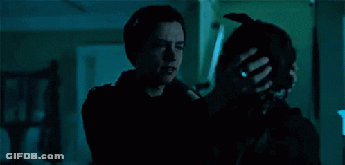 A Man Is Hugging A Woman In A Dark Room While Holding A Dog . GIF