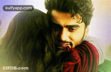 A Man Is Hugging A Woman With The Words Kulfyapp.com Written In The Corner . GIF