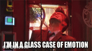 A Man Is In A Glass Case Of Emotion While Looking Out A Window GIF