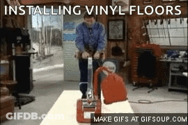 A Man Is Installing Vinyl Floors With A Machine GIF