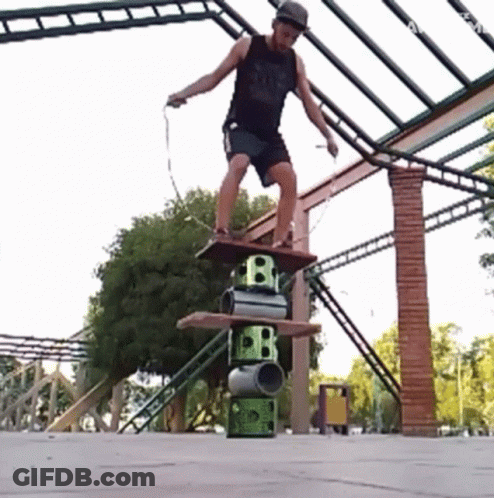 A Man Is Jumping A Rope While Standing On A Stack Of Barrels With The Letter B On Them GIF
