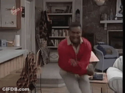 A Man Is Jumping In The Air In A Living Room . GIF