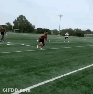 A Man Is Jumping In The Air On A Football Field GIF