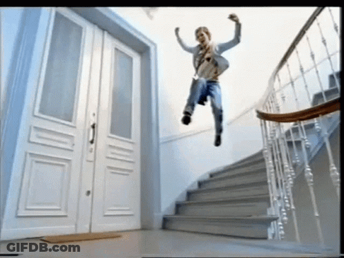 A Man Is Jumping In The Air On A Set Of Stairs With His Arms In The Air GIF